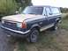 1991 Ford Bronco - Two-tone 1991 Ford Bronco parked outdoors with the driver's door ajar.