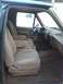 1991 Ford Bronco - The interior of a 1991 Ford Bronco features tan cloth bucket seats with armrests and a matching dashboard.