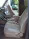 1991 Ford Bronco - Interior view of a vehicle tan cloth bucket seats and a center console with cup holders.