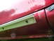 1993 Mazda MX-3 - Close-up of a vehicle's side skirt trim, showing wear and tear.