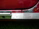 1993 Mazda MX-3 - Close-up of a car's door edge reveals rust and damage, with a ruler indicating measurements.