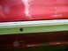 1993 Mazda MX-3 - Detail of a red vehicle's side trim and body panel.