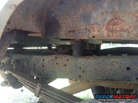 Close-up of heavily rusted vehicle frame and leaf spring suspension components
