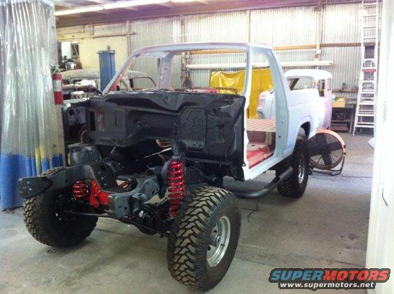 Ford Bronco body stripped down for restoration, showing chassis and suspension components