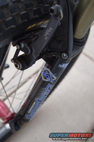 Close-up of a bicycle fork with Shimano XTR brake caliper and tire tread visible