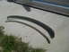 1992 Ford Bronco - Two curved metal trim pieces are shown lying on a concrete surface next to some grass.