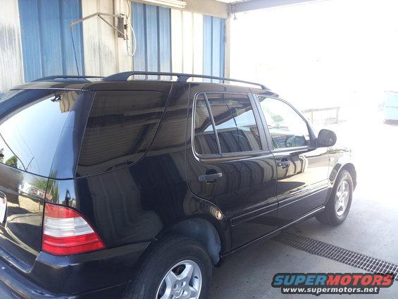 Black SUV parked under a covered area, side view