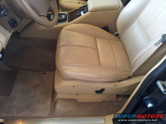 Tan leather driver's seat and dashboard of a 2000 Mercedes-Benz ML-Class, showing wear on the seat