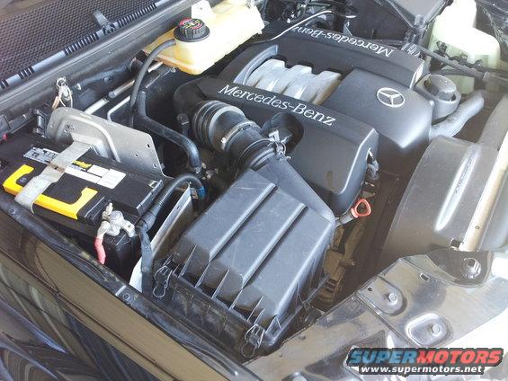 Mercedes-Benz engine bay with visible "Mercedes-Benz" branding on the engine cover