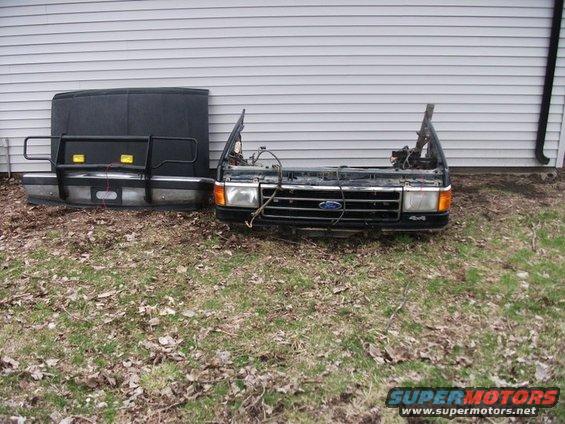 Ford truck front clip with grille and hood leaning against a wall
