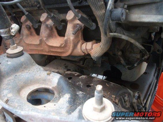 Engine exhaust manifold with spark plug wires and damaged heat shield