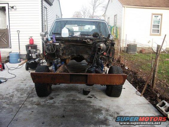 1990 Ford Bronco chassis with engine removed, parked on concrete driveway