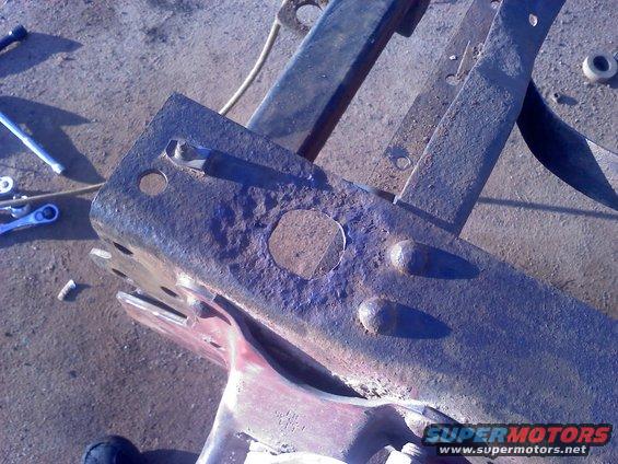 Rusted metal frame part with bolts and holes