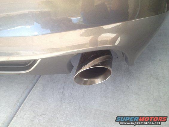 Close-up of a car's exhaust tip with a carbon fiber wrap