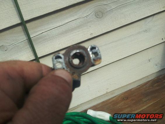 Metal part with circular opening and two mounting points, held in hand
