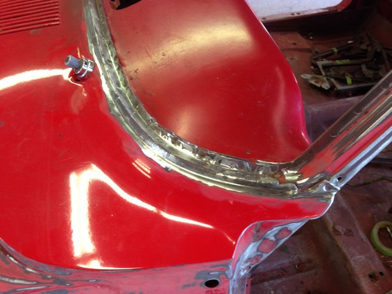 Red car interior showing welded seams around windshield frame