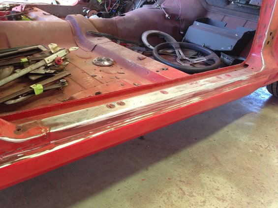 Red car interior with disassembled door components and steering wheel