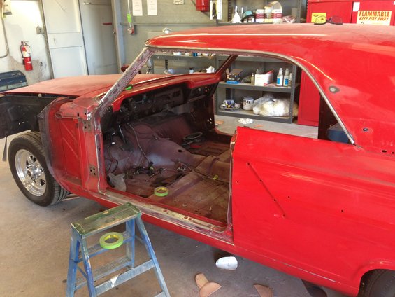 Red 1964 Ford Fairlane interior under restoration, showing stripped dashboard and floor