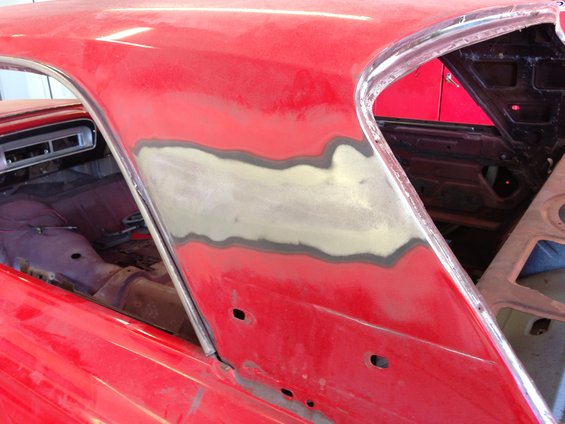 Red 1964 Ford Fairlane bodywork with primer and filler on the rear quarter panel