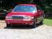1999 Mercury Grand Marquis - Front view of a red sedan with a prominent chrome grille.
