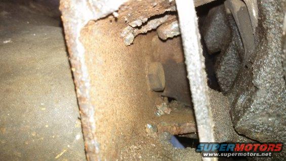 rusted metal frame with a bolt visible inside a cavity
