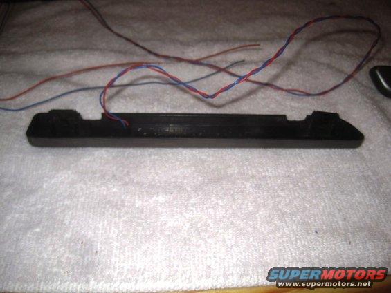 black plastic automotive part with red and blue wires attached