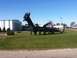 2006 Ford E350 - A large, black, pipe-constructed dragon sculpture stands on a lawn under a clear blue sky.