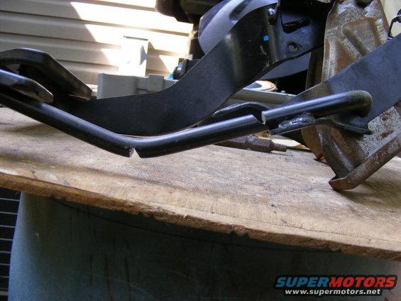 Close-up of a bent and broken metal bracket, possibly from a vehicle's interior