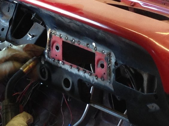 Car dashboard being welded around the radio opening. Wires are visible