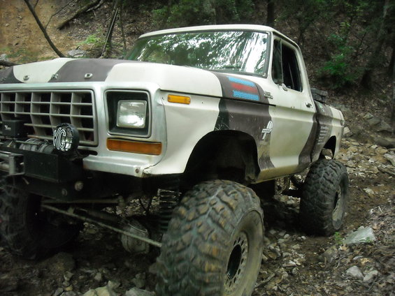 1979 Ford F-150 pickup truck with large off-road tires and camouflage paint