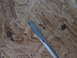 2004 Aston Martin Virage - A flathead screwdriver is shown against a background of particle board.
