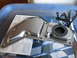 2004 Aston Martin Virage - Metal transmission pan with rubber seal and gasket, placed on top of a document.