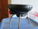2004 Aston Martin Virage - A portable grill with a black lid and red knob sits on a blue container.