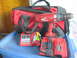 2004 Aston Martin Virage - A red Milwaukee Power-Plus cordless drill is shown with two battery chargers and a red tool bag, all resting on a blue plastic surface.