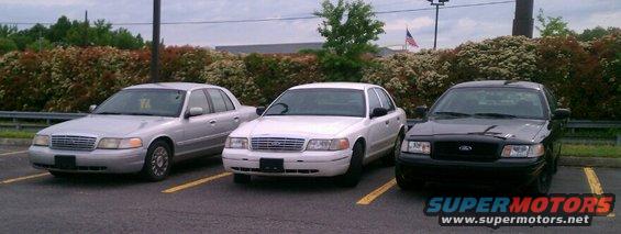 Three Ford Crown Victorias parked in a lot. One is silver, one is white, and one is black