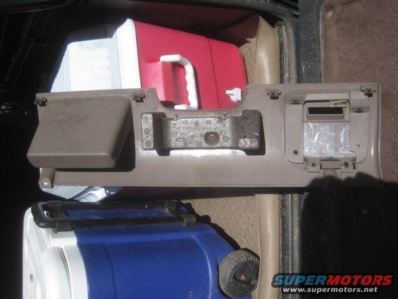 Tan interior car panel with a red and white cooler and a blue cooler behind it