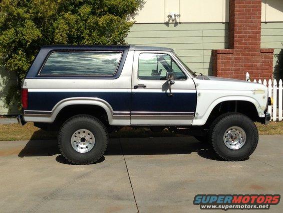 Side view of a lifted Ford Bronco with two-tone paint, dark blue and silver