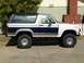 1986 Ford Bronco - This lifted Ford Bronco features a two-tone paint scheme with dark blue and silver accents.