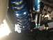 1986 Ford Bronco - Close-up view of a blue coilover shock absorber, with visible text indicating 'SHOCK'.