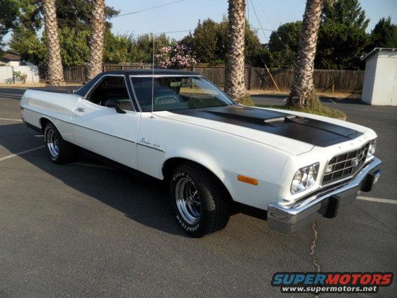 White 1973 Ford Ranchero with black hood stripe, parked on asphalt