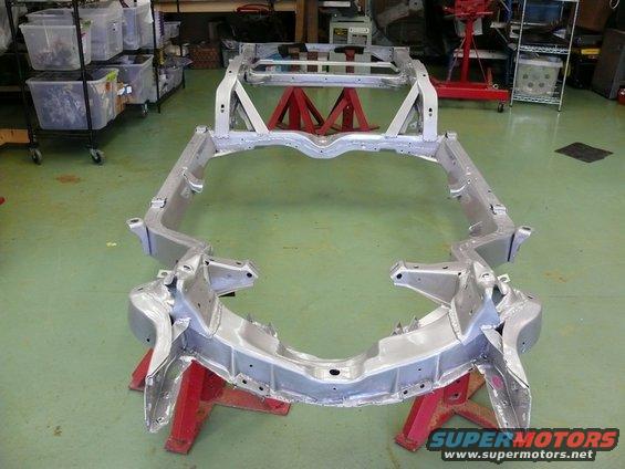 Car frame on red jack stands in a workshop