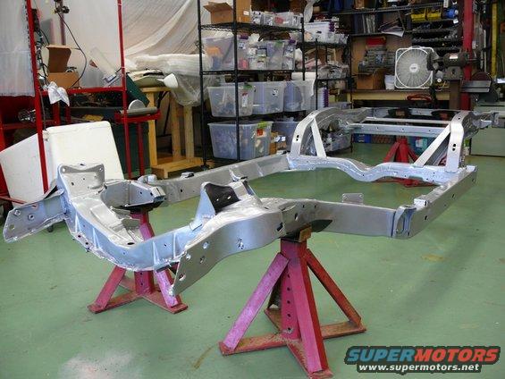 Car frame on red jack stands in a workshop