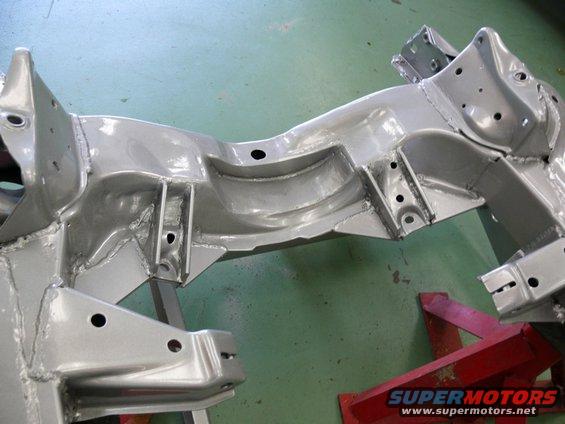 Silver painted car frame on red jack stands