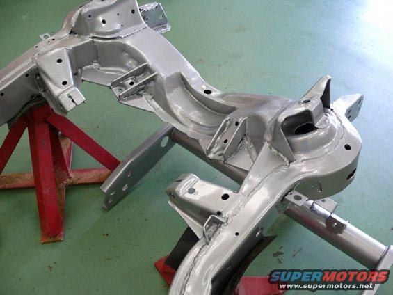 Silver painted car frame chassis sections supported by red jack stands