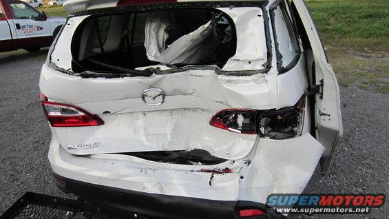 White 2012 Mazda Mazda 5 with heavily damaged rear end and broken taillights