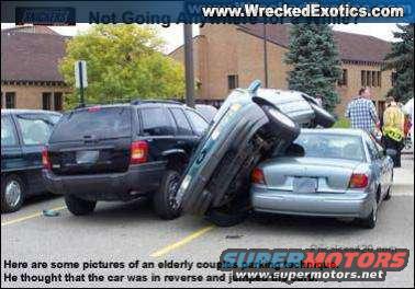 Two cars crashed in a parking lot, one on top of the other