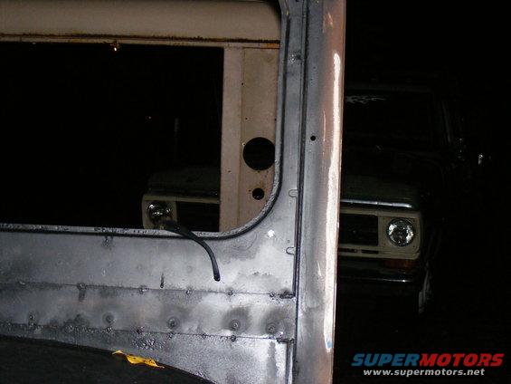 Front view of a 1973 Ford F-Series truck, partially obscured by another vehicle's door