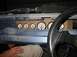 1970 Ford Falcon - A set of aftermarket gauges are installed in a custom dashboard panel, with a steering wheel in the foreground.