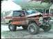1979 Ford Bronco - A lifted pickup truck with significant damage to its front end is parked outdoors, with another vehicle visible behind it.