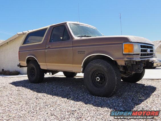 1989 Ford Bronco parked on gravel, front bumper removed